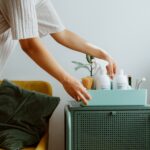A woman organizes self-care products in a stylish room, embodying minimalism and tranquility.
